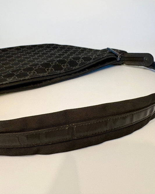 Side view of the black Gucci suede bag, highlighting the curve of the body and the leather strap detail.