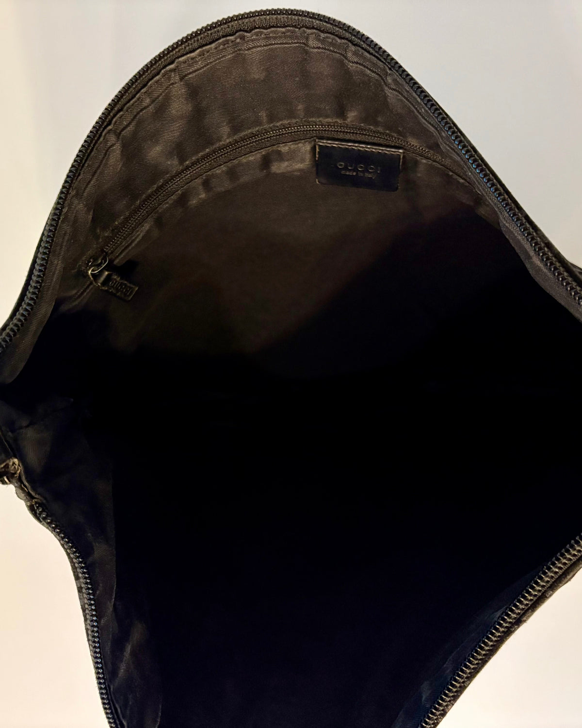 Close-up of the shoulder strap of the Gucci bag, showing the combination of suede, textile and leather trim.