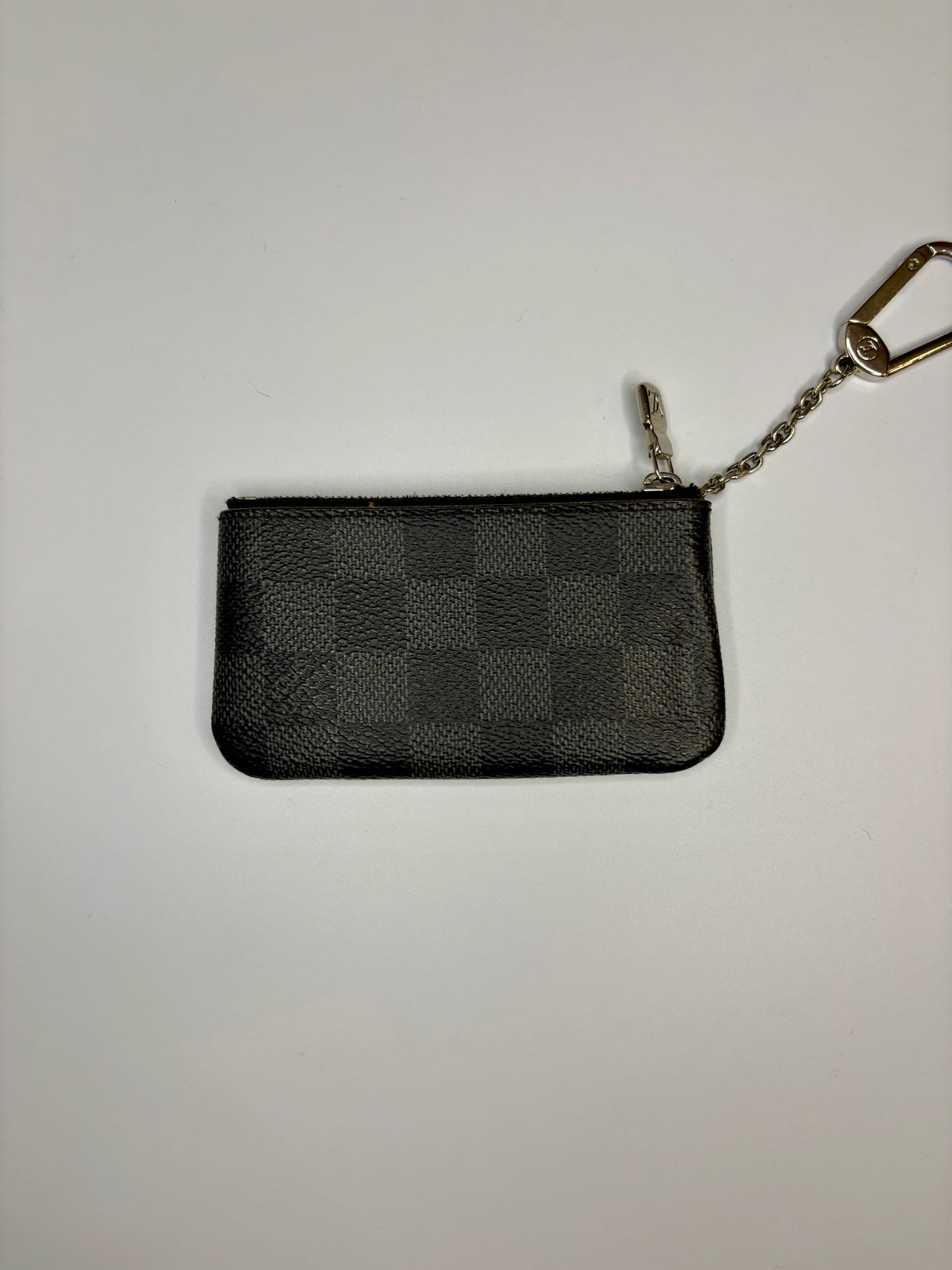 Black leather wallet with keychain on a light gray background