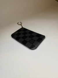 Black checkered wallet on a beige background