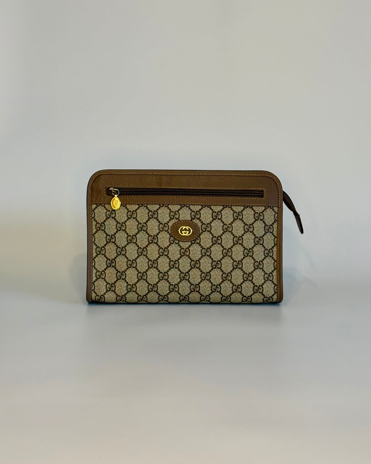 Vintage Gucci GG Supreme pouch in brown canvas, shown from the front with gold-tone details and leather trim.