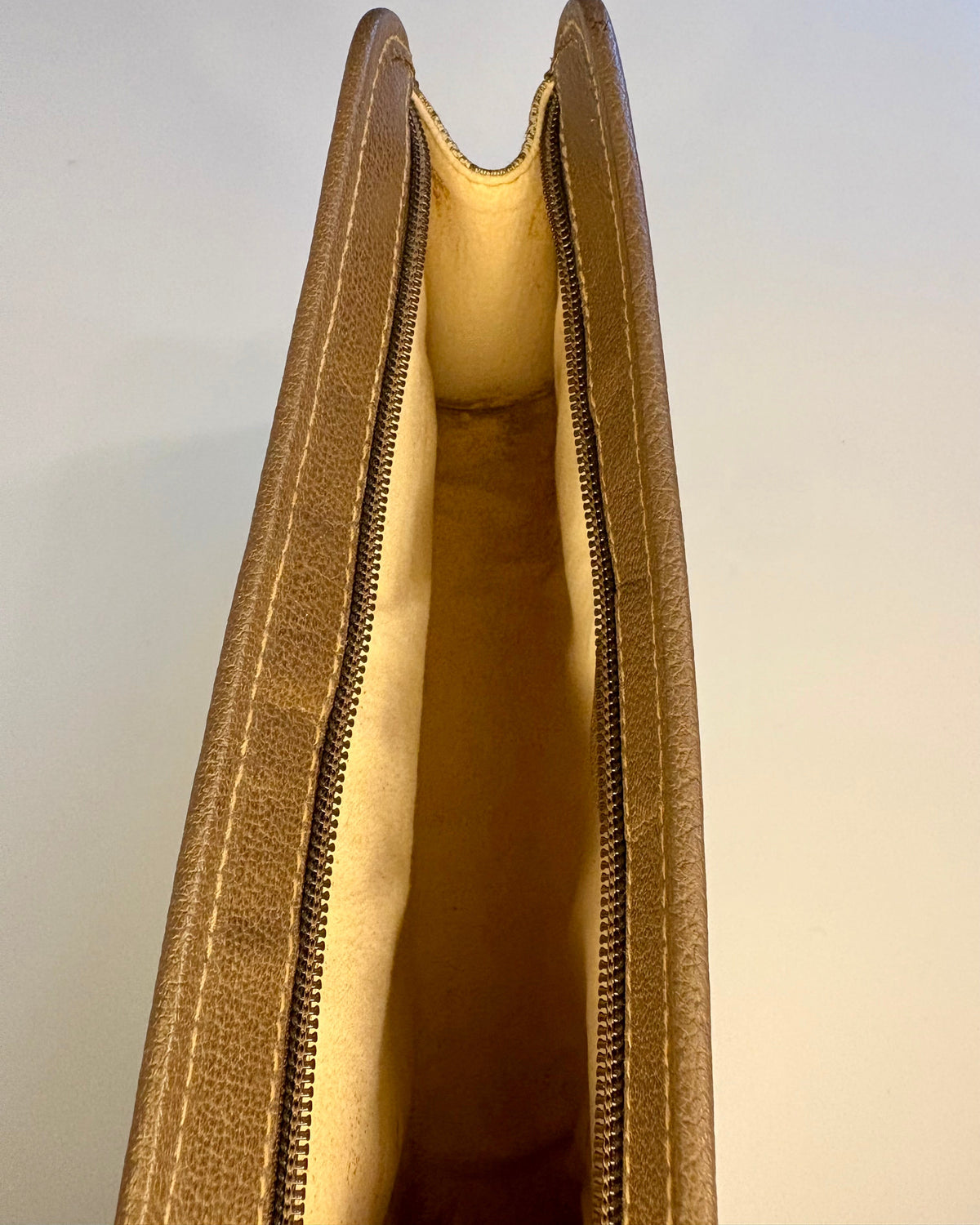 Interior of the vintage Gucci pouch showing the soft beige lining and clean compartment.